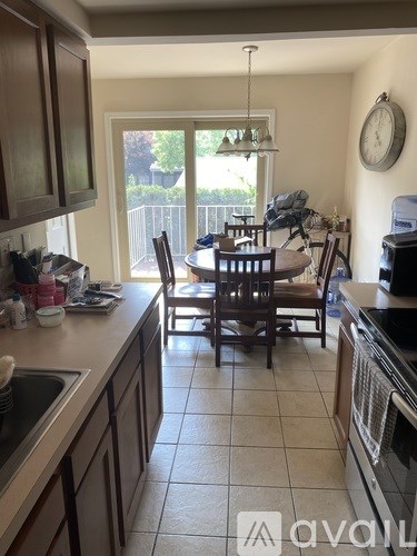 A kitchen with a table and chairs in front of a sliding glass door.