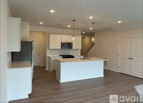 A modern kitchen with white cabinets and a central island.