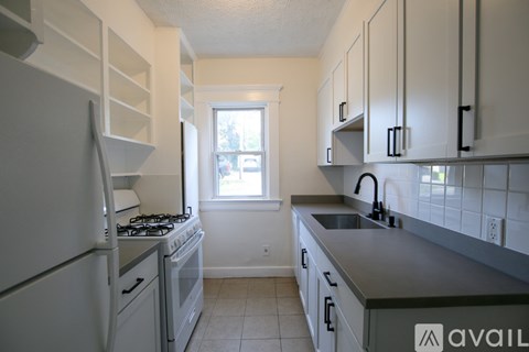 A kitchen with a white refrigerator and a window.