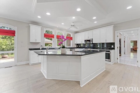 A modern kitchen with white cabinets and a large island.