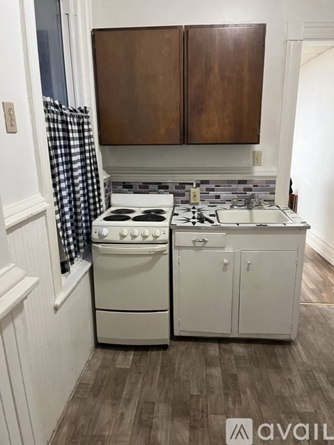 A kitchen with a white stove and cabinets.