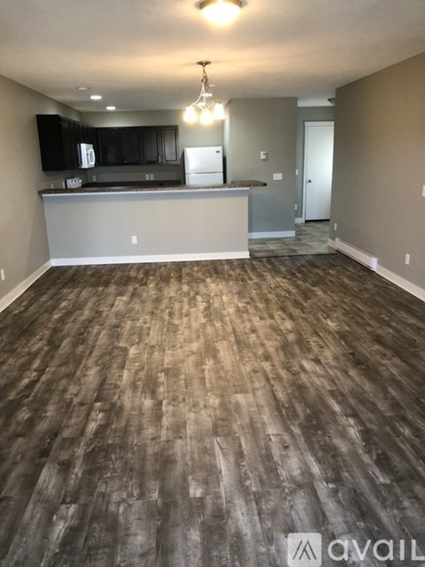 A kitchen with a wooden floor and a white counter.