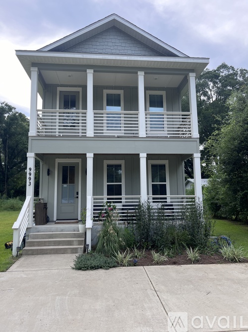 A two-story house with a front porch and a grey roof.