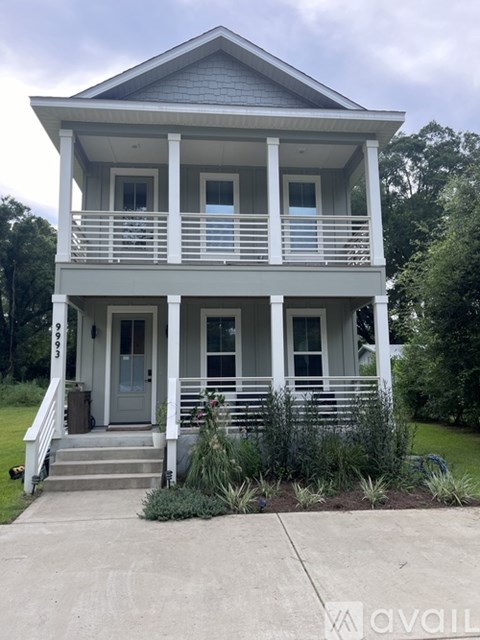 A two-story house with a front porch and a grey roof.