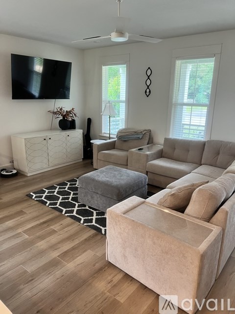 A living room with a grey couch and a white cabinet.