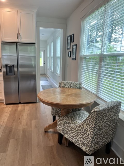 A kitchen with a wooden table and chairs.