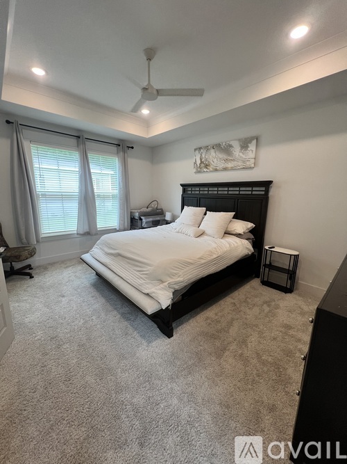 A bedroom with a large bed and a ceiling fan.