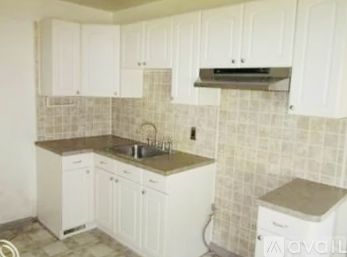 A kitchen with white cabinets and a tiled backsplash.