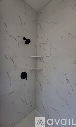 A bathroom with a marble wall and two black circular objects on it.