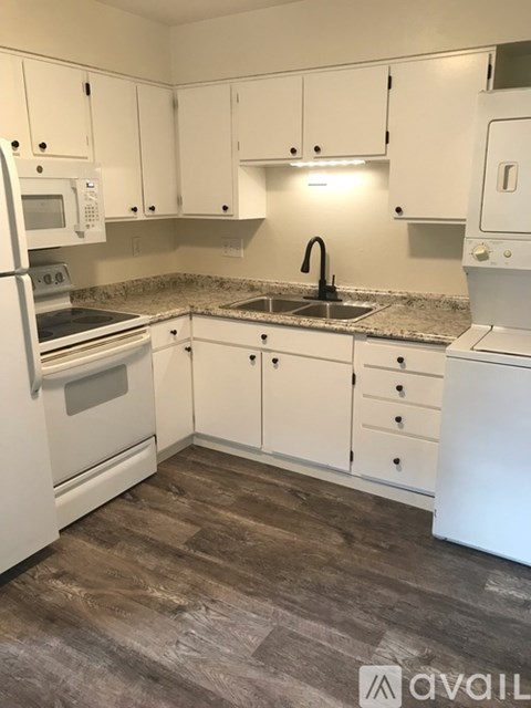 A kitchen with white appliances and cabinets.