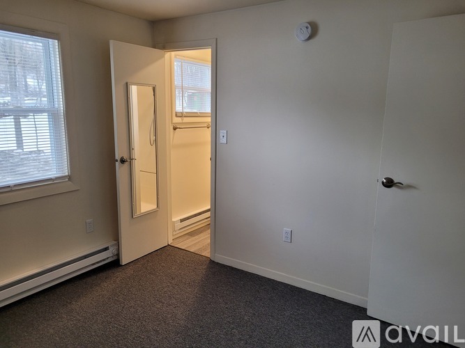 A room with a door leading to a hallway.