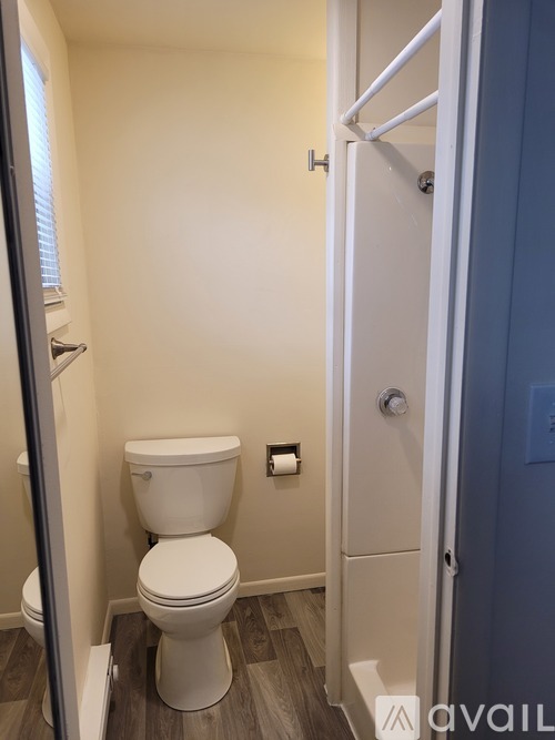 A white toilet in a small bathroom with a white door.