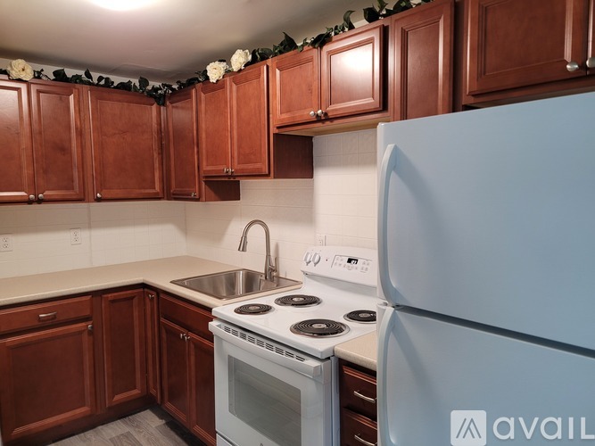A kitchen with brown cabinets and a white refrigerator.