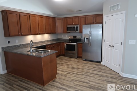 A kitchen with wooden cabinets and a granite countertop.