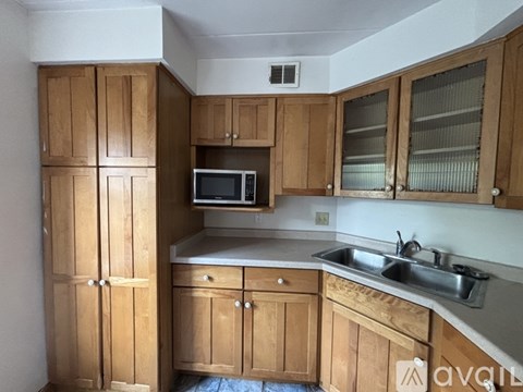 A kitchen with wooden cabinets and a microwave.
