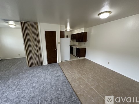 A room with a carpeted floor and a striped curtain.
