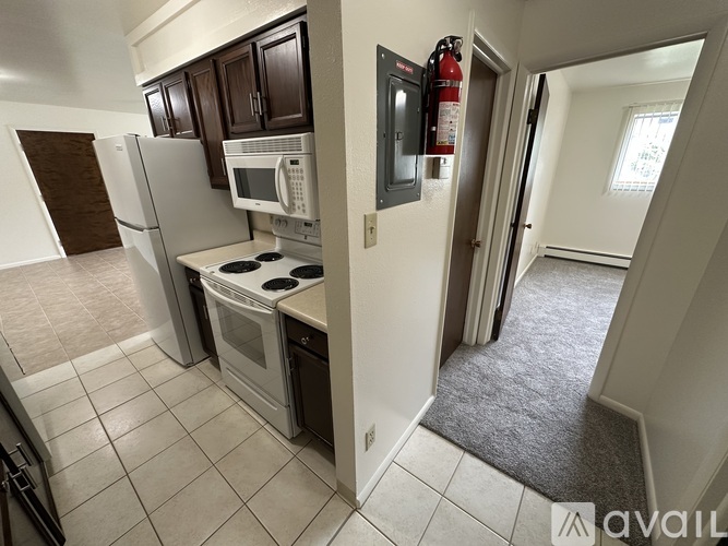 A kitchen with a white fridge, microwave, and oven.