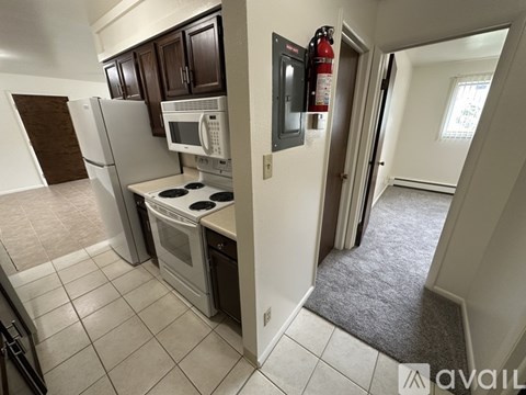 A kitchen with a white fridge, microwave, and oven.