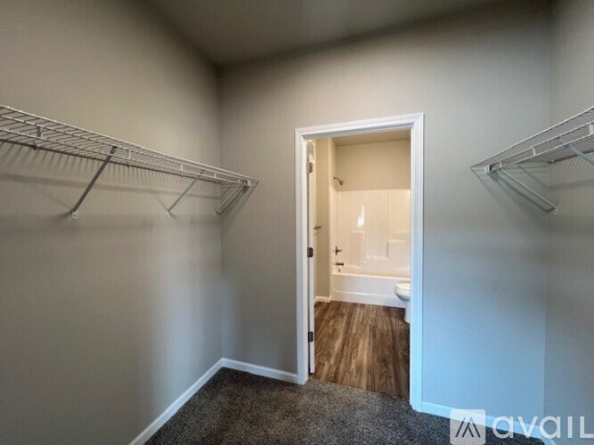 A room with a white door and a carpeted floor.