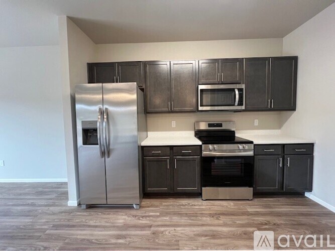 A kitchen with a stainless steel refrigerator, microwave, and oven.