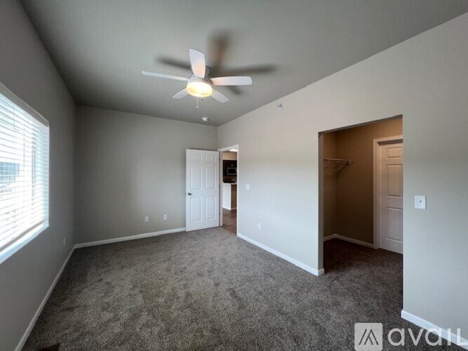 A room with a ceiling fan and carpeted floor.