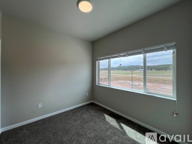 A room with a large window overlooking a field.