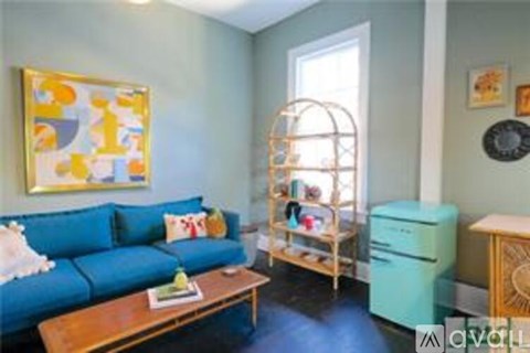 A living room with a blue couch and a wooden coffee table.