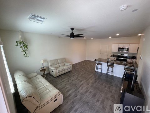 A living room with a white couch and a ceiling fan.