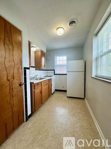 A kitchen with a white refrigerator and wooden cabinets.