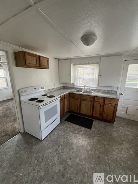 A kitchen with a white stove and wooden cabinets.