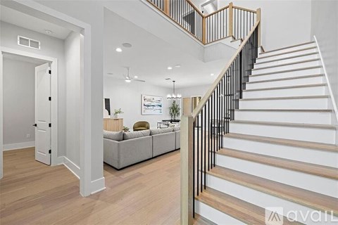 A living room with a couch and a staircase.