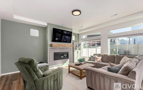 A living room with a green chair and a grey couch.