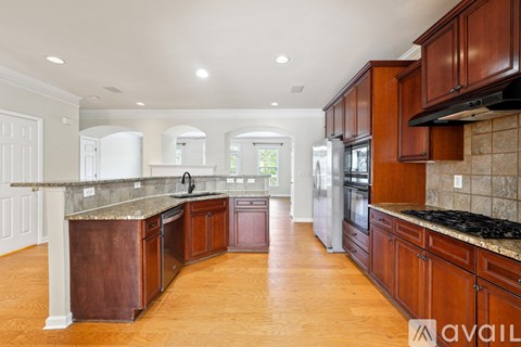 A kitchen with wooden cabinets and a marble countertop.
