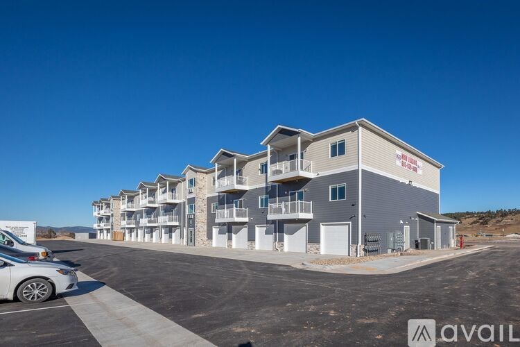 A row of modern townhouses with a car parked in front.