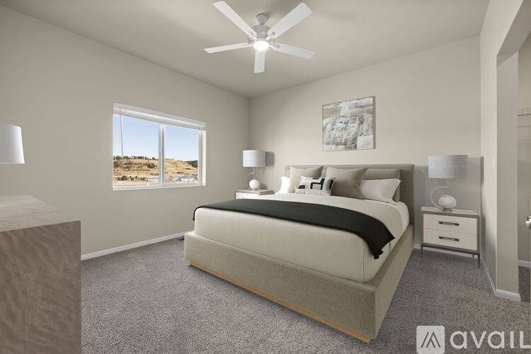 A bedroom with a large bed and a ceiling fan.