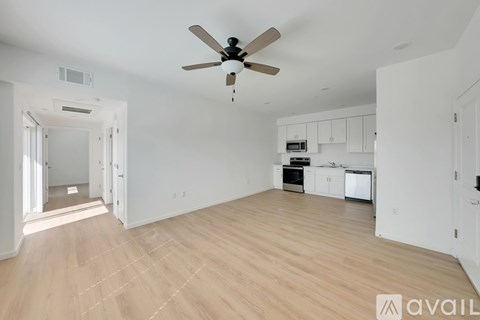 A spacious room with a ceiling fan and wooden flooring.