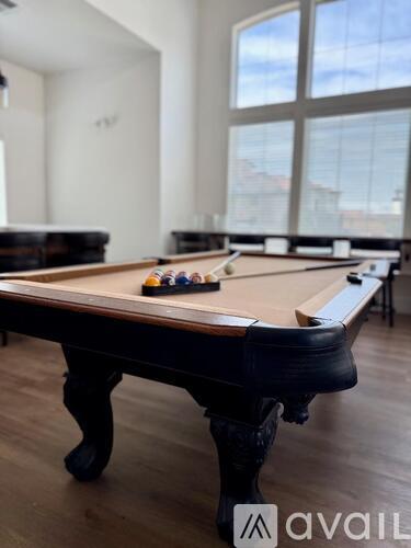 A pool table in a room with a large window.