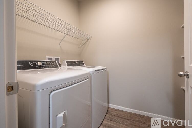 A white dryer and washer are in a small laundry room.