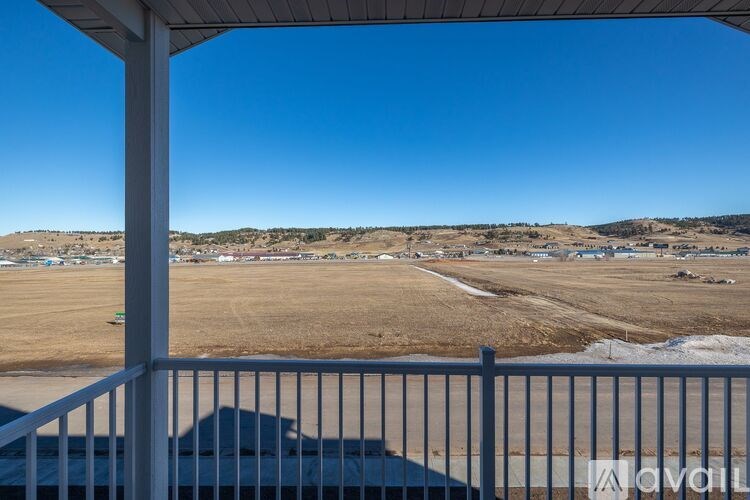 A view from a covered patio looking out over a field.