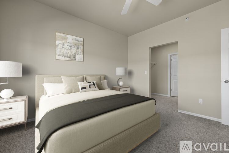 A bedroom with a bed, nightstand, and lamp.