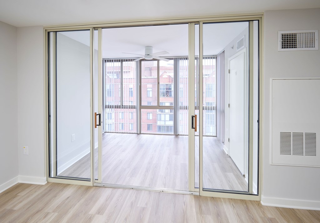 A room with a sliding door leading to a balcony.