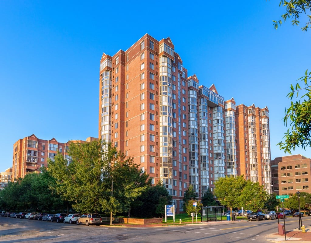 A large red brick building with many windows is in the foreground of the image.