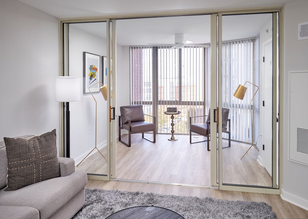A living room with a grey couch and a grey rug.