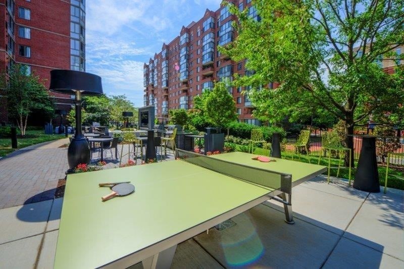 A ping pong table is in the middle of a courtyard.