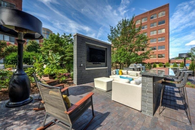 A patio with a TV, chairs, and a table.
