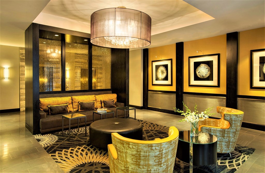 A modern living room with a large sofa, a coffee table, and a chandelier.
