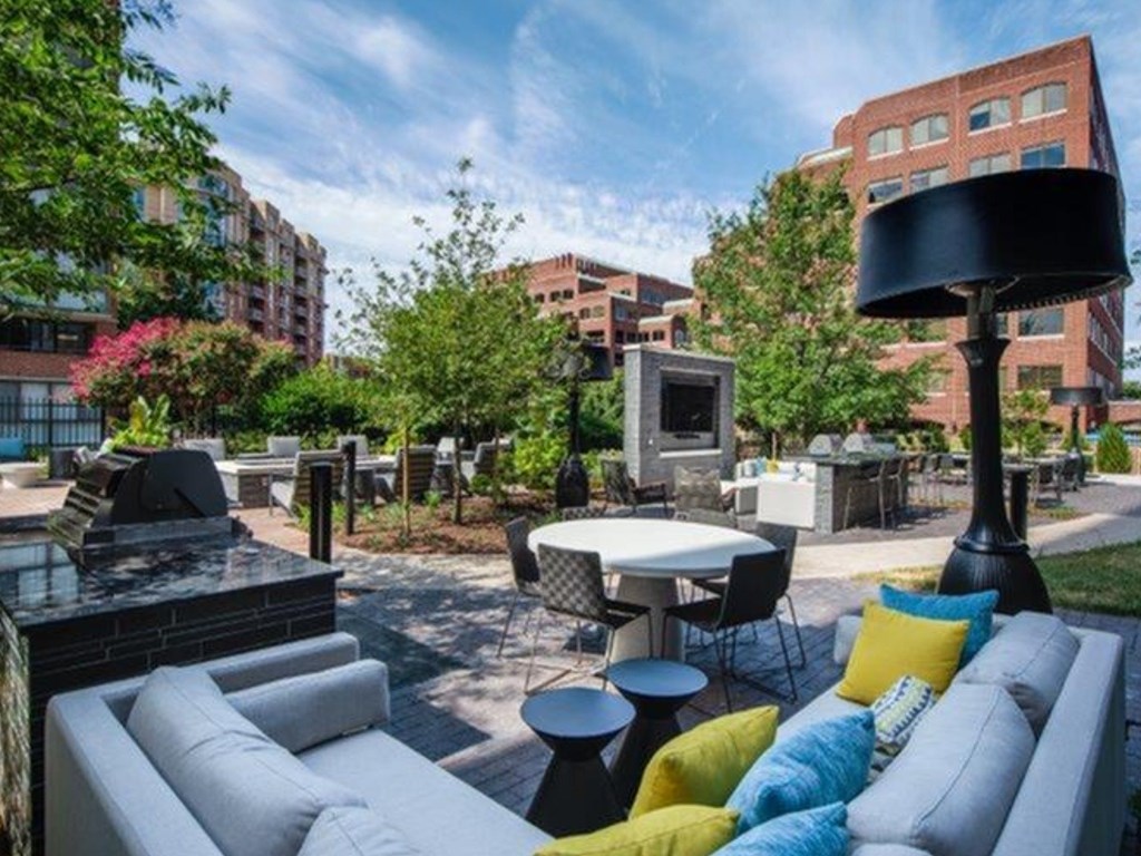 A patio with a table and chairs surrounded by trees.