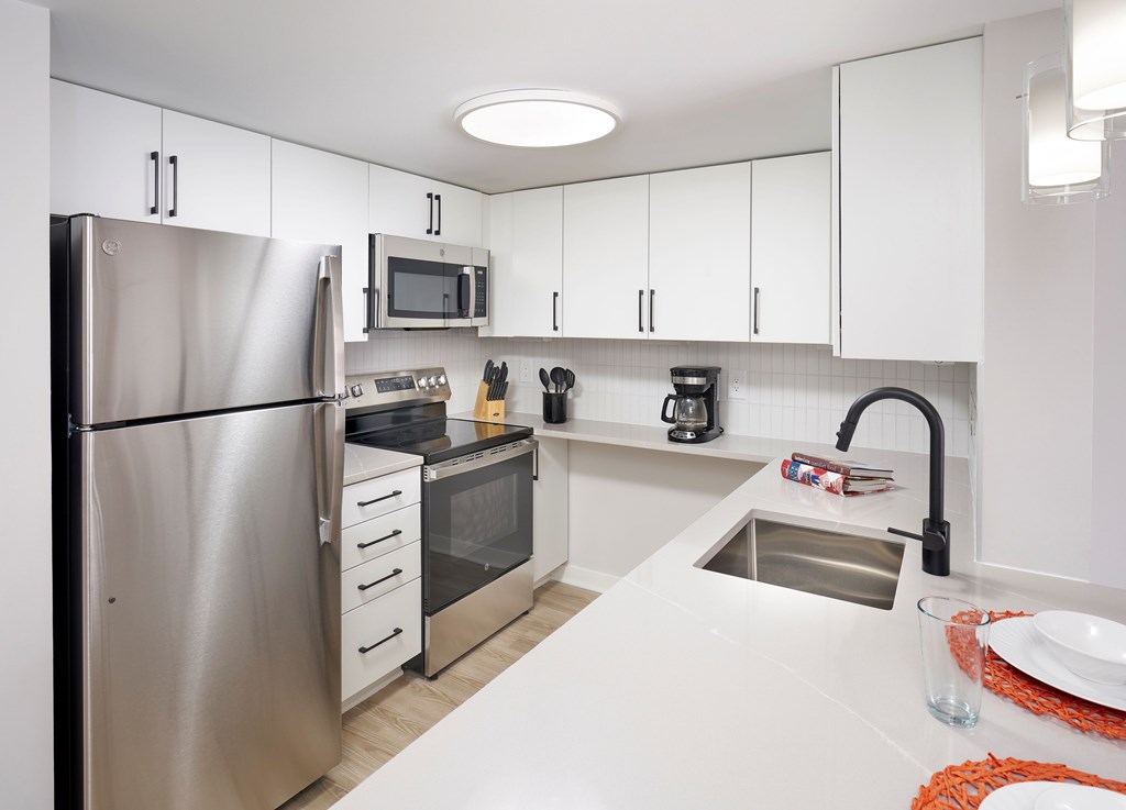 A modern kitchen with stainless steel appliances and white cabinets.