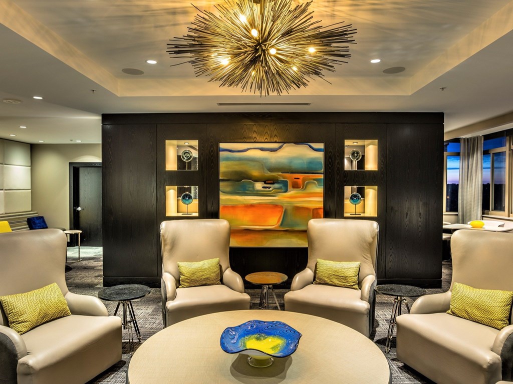A modern living room with a large abstract painting on the wall.