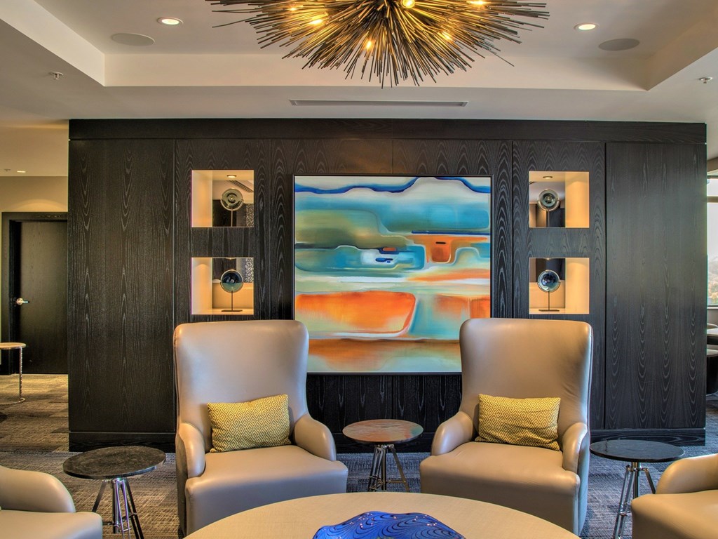 A modern living room with a large abstract painting on the wall.